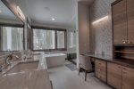 A large bathroom with a makeup vanity and soaking tub 